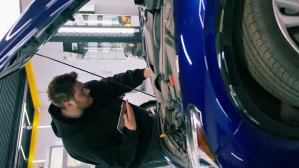 Mécanicien Automobile Masculin Avec Une Tablette Dans Ses Mains Tient — Video