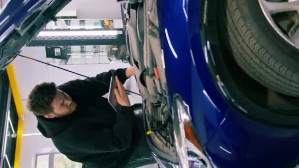 Elinde Tabletle Bir Erkek Oto Tamircisi Açık Mavi Bir Arabanın — Stok video