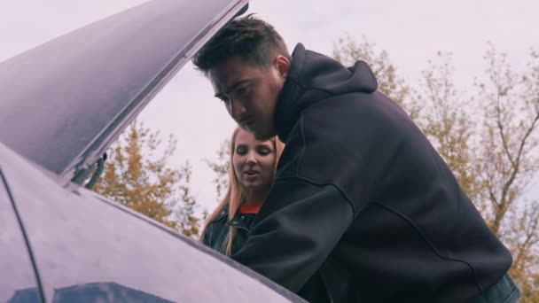 Молода Пара Стоїть Біля Розбитого Автомобіля Відкритим Капюшоном Чоловік Пояснює — стокове відео