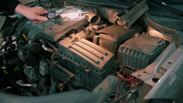 Egy Férfi Autószerelő Zseblámpával Kezében Ellenőrzi Autó Motorját Hibákat Keres — Stock videók