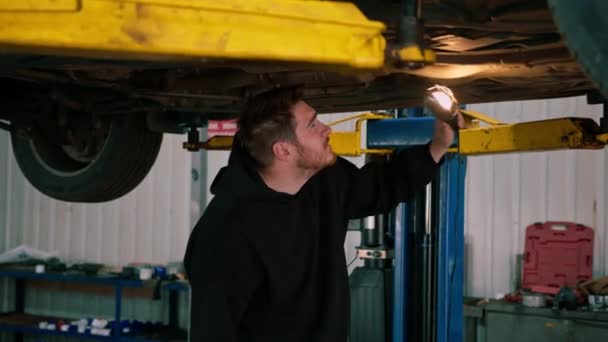 Elinde Feneri Olan Erkek Tamirci Arabanın Tabanını Inceler Arabanın Süspansiyonunda — Stok video