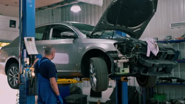 Работник Автосервиса Поднимает Роскошный Серый Автомобиль Синий Лифт Проверить Автомобиль — стоковое видео