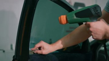 Erkek araba servisi çalışanı, camları yapıştırıyor. Lüks arabaları boyuyor, arabaları temizliyor. Araba sevgisi ve koruma kavramını onarıyor.