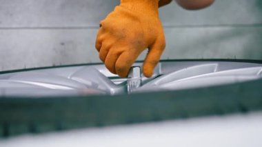 Otomotiv tamircisi, lüks beyaz bir arabanın tekerleğini değiştiriyor. Yakından çekilen bir araba servisinde balon anahtarı kullanıyor.