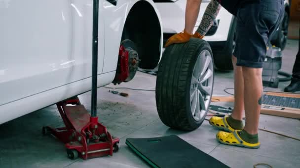 Otomotiv Tamircisi Lüks Beyaz Bir Arabanın Tekerleğini Değiştiriyor Yakından Çekilen — Stok video