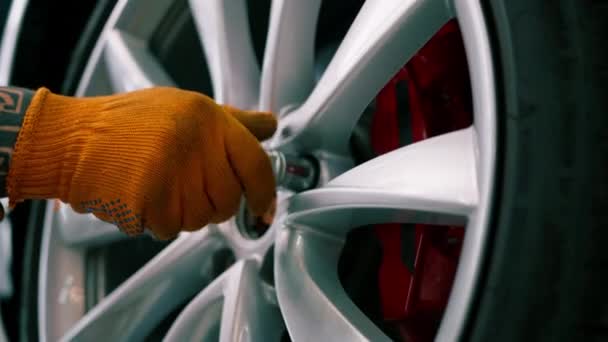 Автоматичний Чоловік Змінює Колесо Розкішному Білому Автомобілі Використовуючи Кульовий Ключ — стокове відео