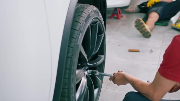 Otomotiv Tamircisi Lüks Beyaz Bir Arabanın Tekerleğini Değiştiriyor Yakından Çekilen — Stok video