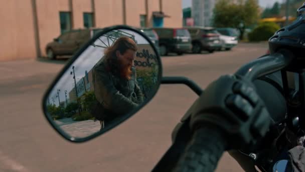 在比赛开始前带着胡子的野蛮红头发骑自行车的人在侧面的镜子前走近摩托车 — 图库视频影像