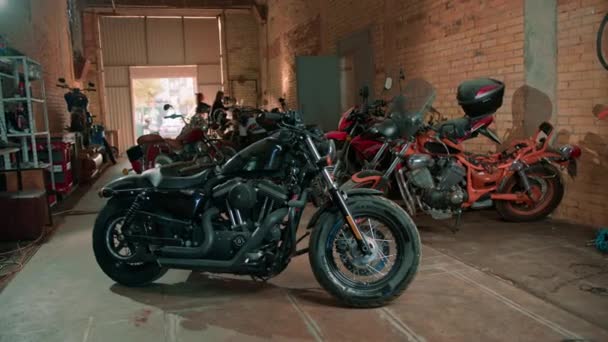 創造的な本物のオートバイの研修会 多くの異なったオートバイは修理のためのガレージで立っています — ストック動画