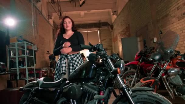 Autentyczne Warsztaty Motocyklowe Garaż Piękny Młody Rowerzysta Dziewczyna Stoi Pobliżu — Wideo stockowe