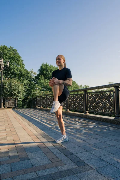 健康的年轻女运动员在早上进行热身运动 然后在城市街头进行有关桥牌运动健康的训练 — 图库照片