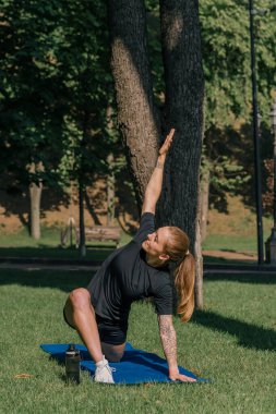 Genç spor kızı spor sahasının üzerinde egzersiz yapıyor. Spor parkı sağlıklı yaşam tarzı konsepti sırasında.