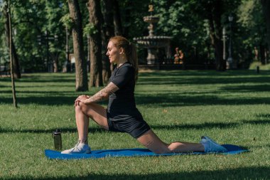 Genç spor kızı spor sahasının üzerinde egzersiz yapıyor. Spor parkı sağlıklı yaşam tarzı konsepti sırasında.