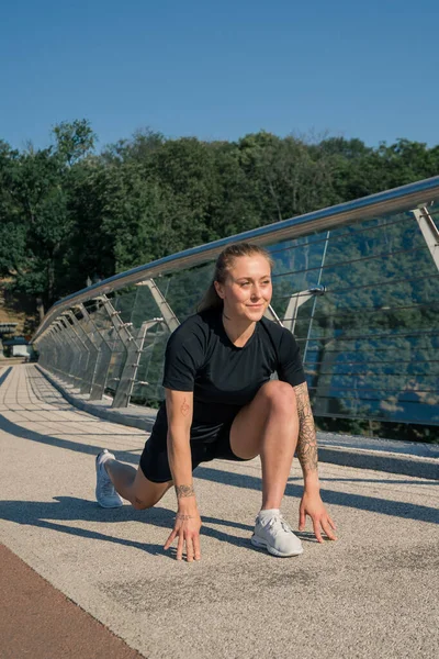健康的年轻女运动员在早上进行热身运动 然后在城市街头进行有关桥牌运动健康的训练 — 图库照片