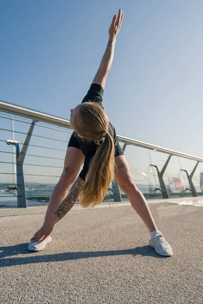 健康的年轻女运动员在早上做热身运动 然后在城市的街道上进行有关运动健康的训练 — 图库照片