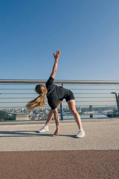 健康的年轻女运动员在早上做热身运动 然后在城市的街道上进行有关运动健康的训练 — 图库照片