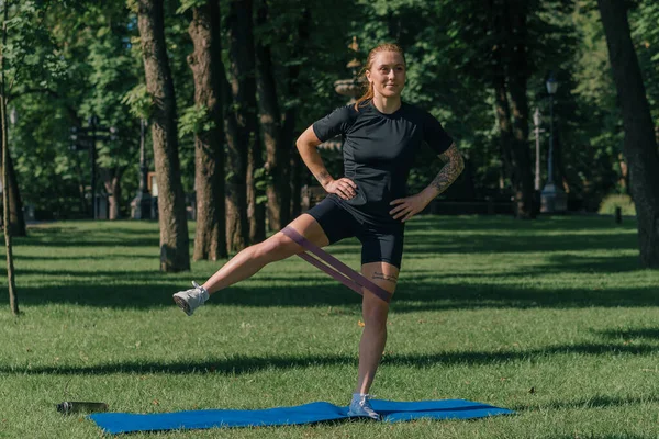 Genç Sporcu Kız Spor Minderinde Egzersiz Yapıyor Bacaklarında Lastik Bantlarla — Stok fotoğraf