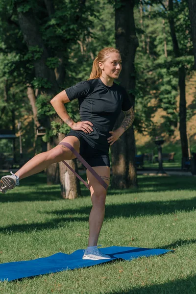 Genç Sporcu Kız Spor Minderinde Egzersiz Yapıyor Bacaklarında Lastik Bantlarla — Stok fotoğraf