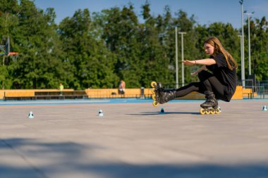 Sportif kız şehir arka planında paten üzerinde paten numarası yapıyor. Paten derslerinin keyfini çıkarıyor. Cipsler yakın sokak sporları konseptiyle.