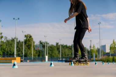 Sportif kız şehir arka planında paten üzerinde paten numarası yapıyor. Paten derslerinin keyfini çıkarıyor. Cipsler yakın sokak sporları konseptiyle.