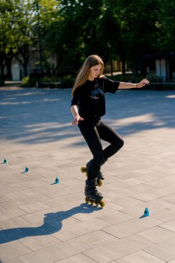 Sportif kız şehir arka planında paten üzerinde paten numarası yapıyor. Paten derslerinin keyfini çıkarıyor. Cipsler yakın sokak sporları konseptiyle.