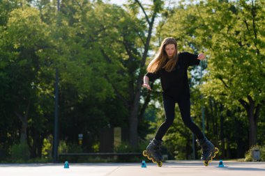 Sportif kız şehir arka planında paten üzerinde paten numarası yapıyor. Paten derslerinin keyfini çıkarıyor. Cipsler yakın sokak sporları konseptiyle.