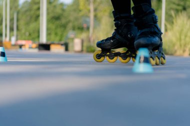 Sportif kız şehir arka planında paten üzerinde paten numarası yapıyor. Sokak sporuna yakın cipslerle paten dersinin keyfini çıkarıyor.