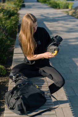 Parktaki genç ve güzel kız, aktif yaşam tarzı eğitimi almadan önce paten kayıyor ve paten kayıyor.