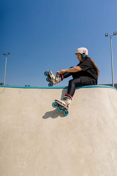 Junges Hipster Mädchen Mit Schutzhelm Auf Rollschuhen Bindet Schnürsenkel Skatepark — Stockfoto
