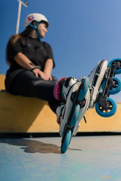 스케이트 클로즈업 바퀴를 스케이트 공원에서 배경에 헬멧에 힙스터 — 스톡 사진