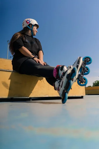 스케이트 클로즈업 바퀴를 스케이트 공원에서 배경에 헬멧에 힙스터 — 스톡 사진