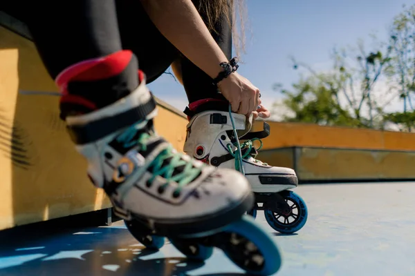 年轻的嬉皮士女孩穿着旱冰鞋 在溜冰街极限运动的腿特写前 在溜冰场系鞋带 — 图库照片