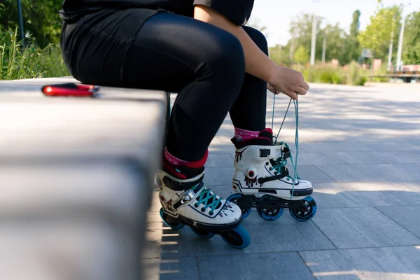 スケートパークでレースを結ぶローラースケートを身に着けている若いヒップスターガールは 脚のストリート極端なスポーツクローズアップをスケートする前に — ストック写真