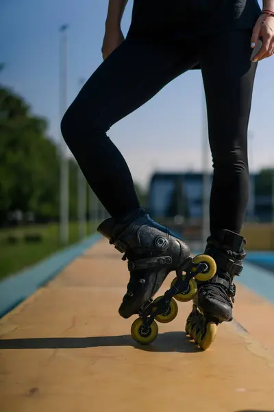 スポーティガール トリック パークシティの背景でローラースケート ローラースケートレッスンを楽しむ 足のストリートスポーツを閉じる — ストック写真
