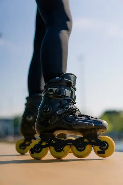 在公园城市背景下练习轮滑技巧的女运动员喜欢轮滑课近腿街头运动 — 图库照片