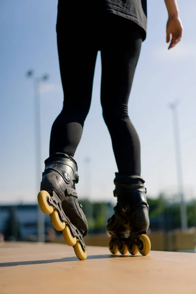 スポーティガール トリック パークシティの背景でローラースケート ローラースケートレッスンを楽しむ 足のストリートスポーツを閉じる — ストック写真