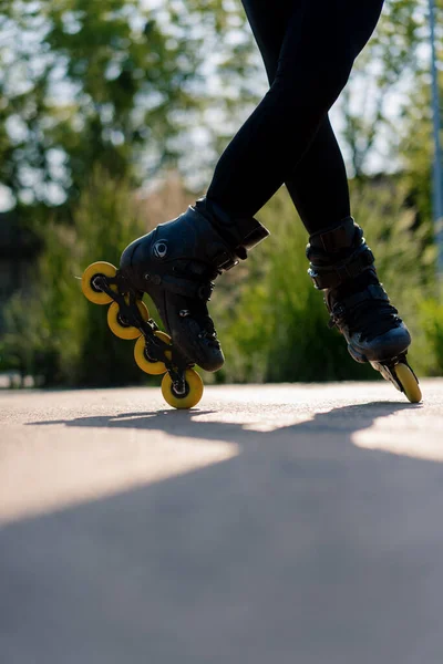 スポーティな女の子は ローラースケートレッスンを楽しむ街の背景に公園でローラースケートのトリックを実践 ホイールストリートスポーツコンセプトを閉じる — ストック写真