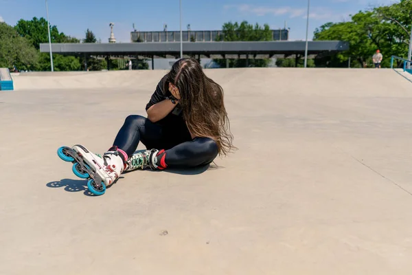 ローラーリンクのローラーに落ちた後怒る少女 失敗したスケート傷害アクティブレクリエーション趣味 — ストック写真