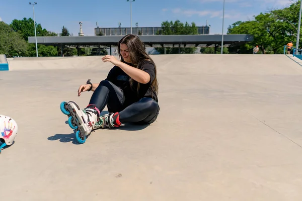 動揺する迷惑な女の子のローラーブレード ローラーのドロムは保護ヘルメットのアスファルトの活動的なレクリエーションのスケートのスポーツ趣味を投げます — ストック写真
