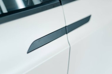 Araba temizliği ve kuru temizleme sırasında araba servisinde siyah saplı, lüks beyaz elektrikli arabanın kapısı.