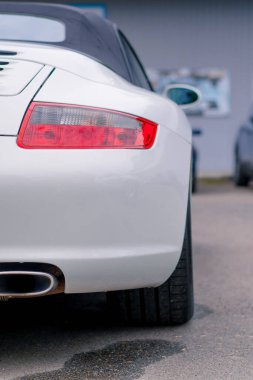 Servis istasyonunda yıkandıktan sonra beyaz lüks bir arabanın tampon ve stop lambasını detaylandırmak