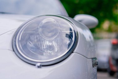 Araba servisinde yıkandıktan sonra beyaz lüks bir arabanın tampon ve farlarının ayrıntıları.