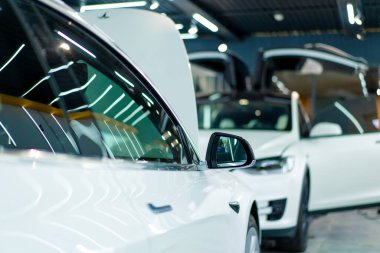 Araba servisinde ya da otoparkta yıkama ve kuru temizleme yaptıktan sonra beyaz lüks bir arabanın kapısı ve aynasının ayrıntıları.