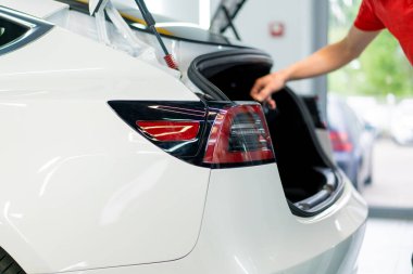 Servis istasyonunda yıkandıktan sonra beyaz lüks bir arabanın tampon ve stop lambasını detaylandırmak