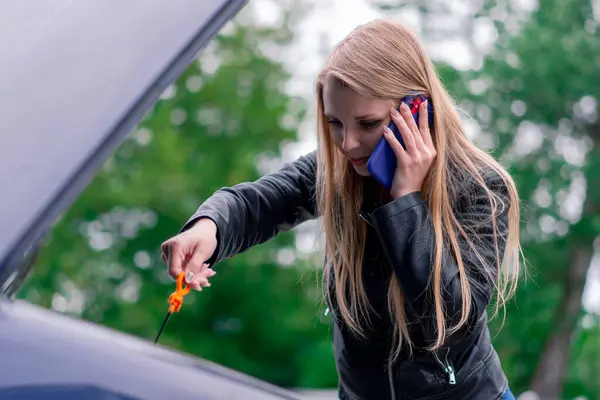 Üzgün Çekici Bir Kız Arabanın Yanında Duruyor Kaputu Açık Telefonla — Stok fotoğraf