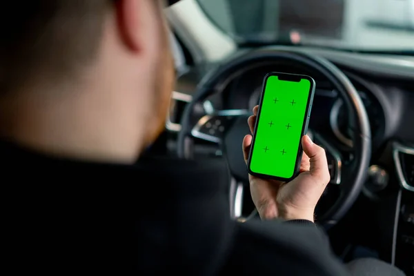 Mężczyzna Siedzi Luksusowym Samochodzie Zielonym Telefonem Rękach — Zdjęcie stockowe