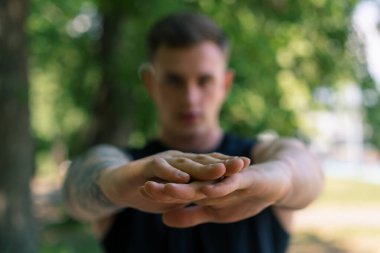 Dövmeleri olan genç bir sporcunun portresi. Açık hava sokak eğitimleri yapıyor. Park motivasyonu üzerine.
