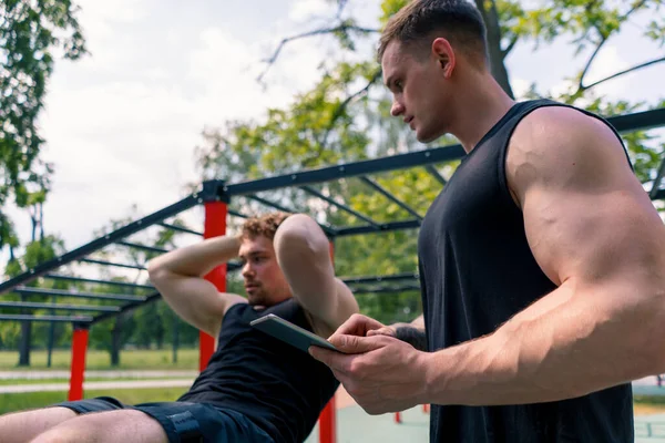 Treinador Fitness Com Tablet Suas Mãos Treina Jovem Atleta Bombeando — Fotografia de Stock