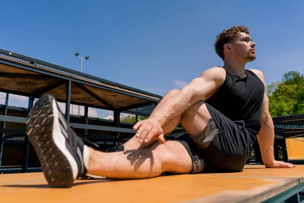 若いポンプアップスポーツマンボディービルダーストリートワークアウトスポーツグラウンド中に脚肺 — ストック写真