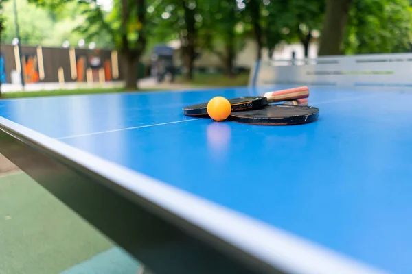 Tenis Raketi Turuncu Bir Tenis Topu Mavi Bir Tenis Masasının — Stok fotoğraf